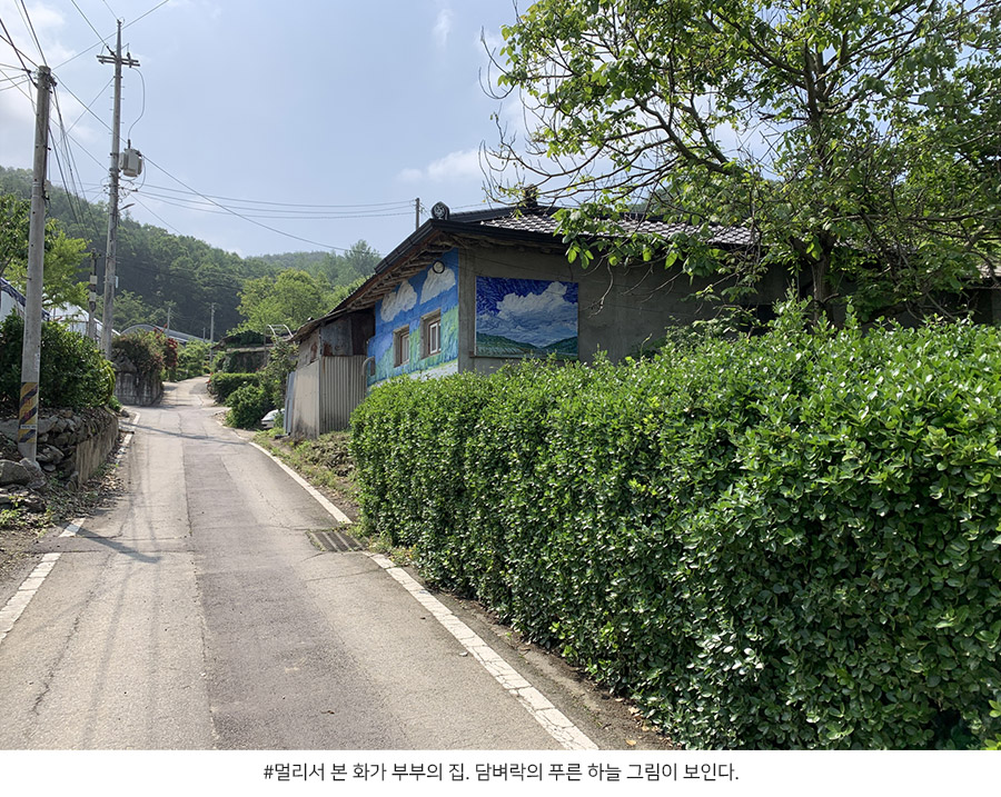 멀리서 본 화가 부부의 집. 담벼락의 푸른 하늘 그림이 보인다.